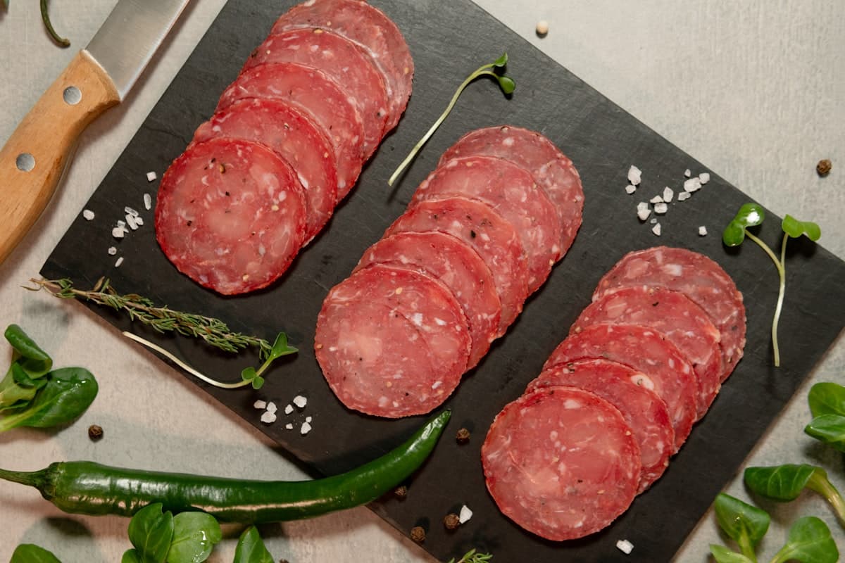 Fines tranches de charcuterie disposées sur une ardoise